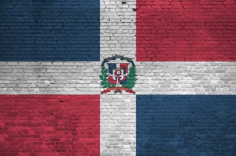 Dominican Republic flag depicted in paint colors on old brick wall close up